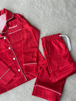 Load image into Gallery viewer, These include a button up shirt with your personalised name above the pocket and trousers, with pockets on either side and an adjustable tie around the waist. The perfect personalised gift for children! Red body colour with a White contrast piping and buttons. Personalised for you!