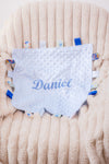 Baby boy blue personalised  soft plush comforter. Personalisation embroidered in the middle in light blue which complements the accent tags around the edges. A nice square soft comforter to help keep the little one content.