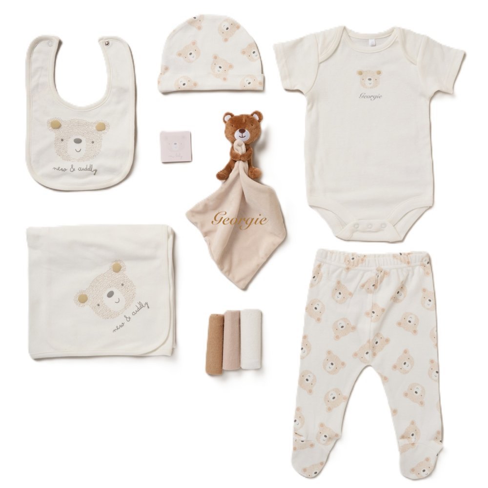 A collection of baby items including a bib, body vest, hat, leggings, blanket, muslins, teddy bear comforter, and all presented in a lovely mesh gift bag. A personalised a teddy bear beige design soft cotton comfortable set, perfect for a baby shower gift or any new arrival!  