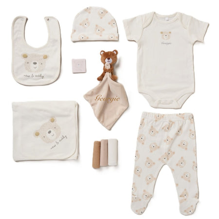 A collection of baby items including a bib, body vest, hat, leggings, blanket, muslins, teddy bear comforter, and all presented in a lovely mesh gift bag. A personalised a teddy bear beige design soft cotton comfortable set, perfect for a baby shower gift or any new arrival!  