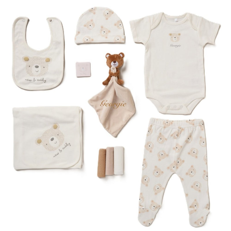 A collection of baby items including a bib, body vest, hat, leggings, blanket, muslins, teddy bear comforter, and all presented in a lovely mesh gift bag. A personalised a teddy bear beige design soft cotton comfortable set, perfect for a baby shower gift or any new arrival!  