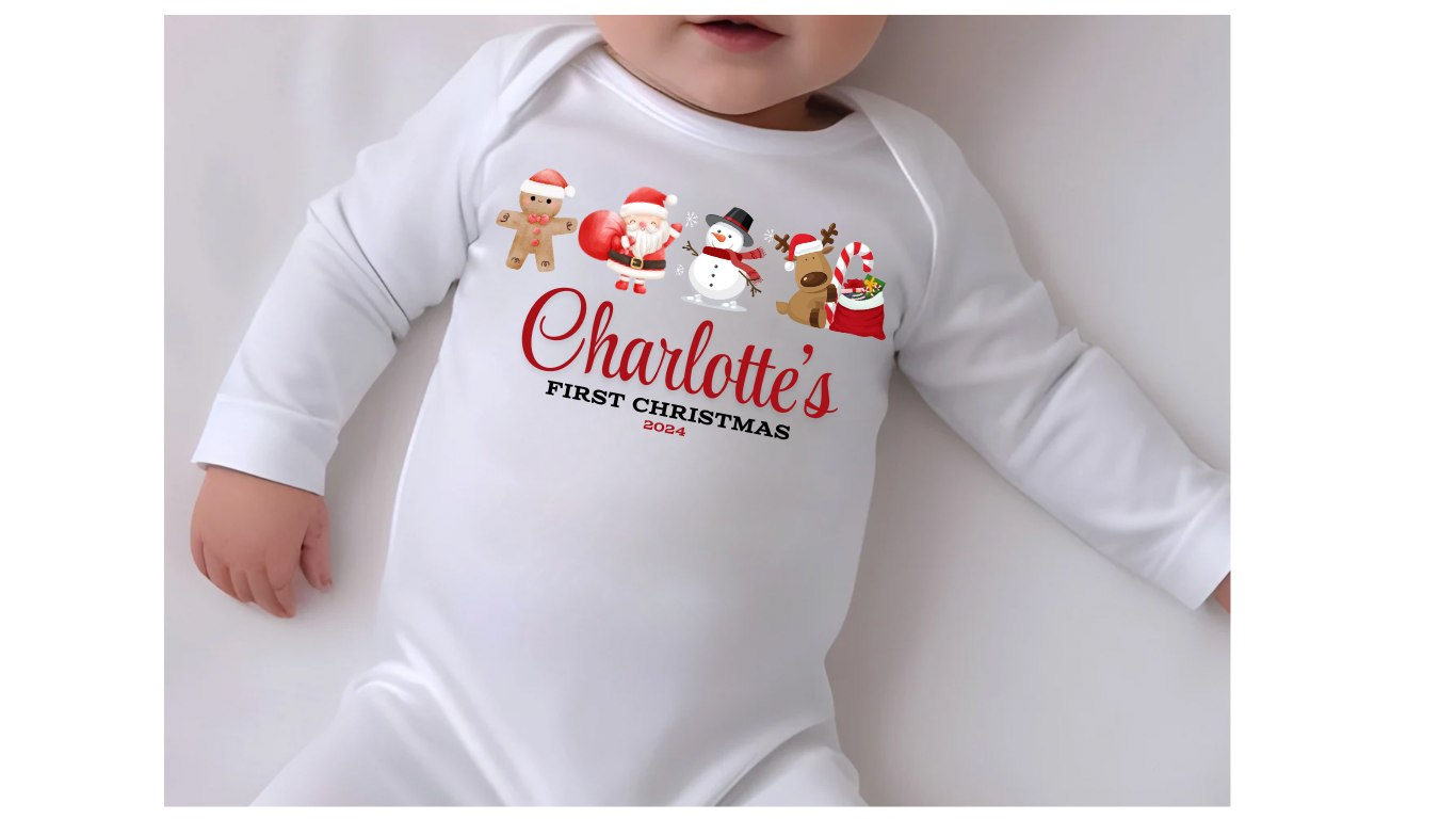 A white personalised unisex soft cotton 
 sleep suit for babies with a Christmas theme, including a design with Santa Claus, reindeer, a snowman and the gingerbread man. Personalisation to the middle in red print with first Christmas written below. A sure way to get a first Christmas photo of your baby. 