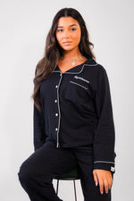 Load image into Gallery viewer, A beautiful set of ladies personalised black jersey pyjamas. Soft and comfortable personalisation above the front pocket on the left chest . white contrasting trim around the collar alongside the buttons down to the front, also around the ankles and wrist . A nice classy design with your comfort in mind. 
