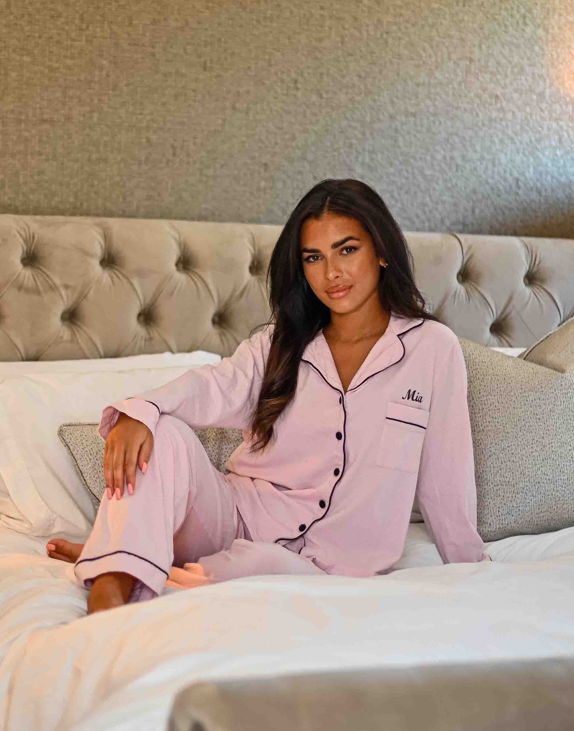 A beautiful set of ladies personalised pink jersey pyjamas. Soft and comfortable personalisation above the front pocket on the left chest . Black contrasting trim around the collar alongside the buttons down to the front, also around the ankles and wrist . A nice classy design with your comfort in mind. 