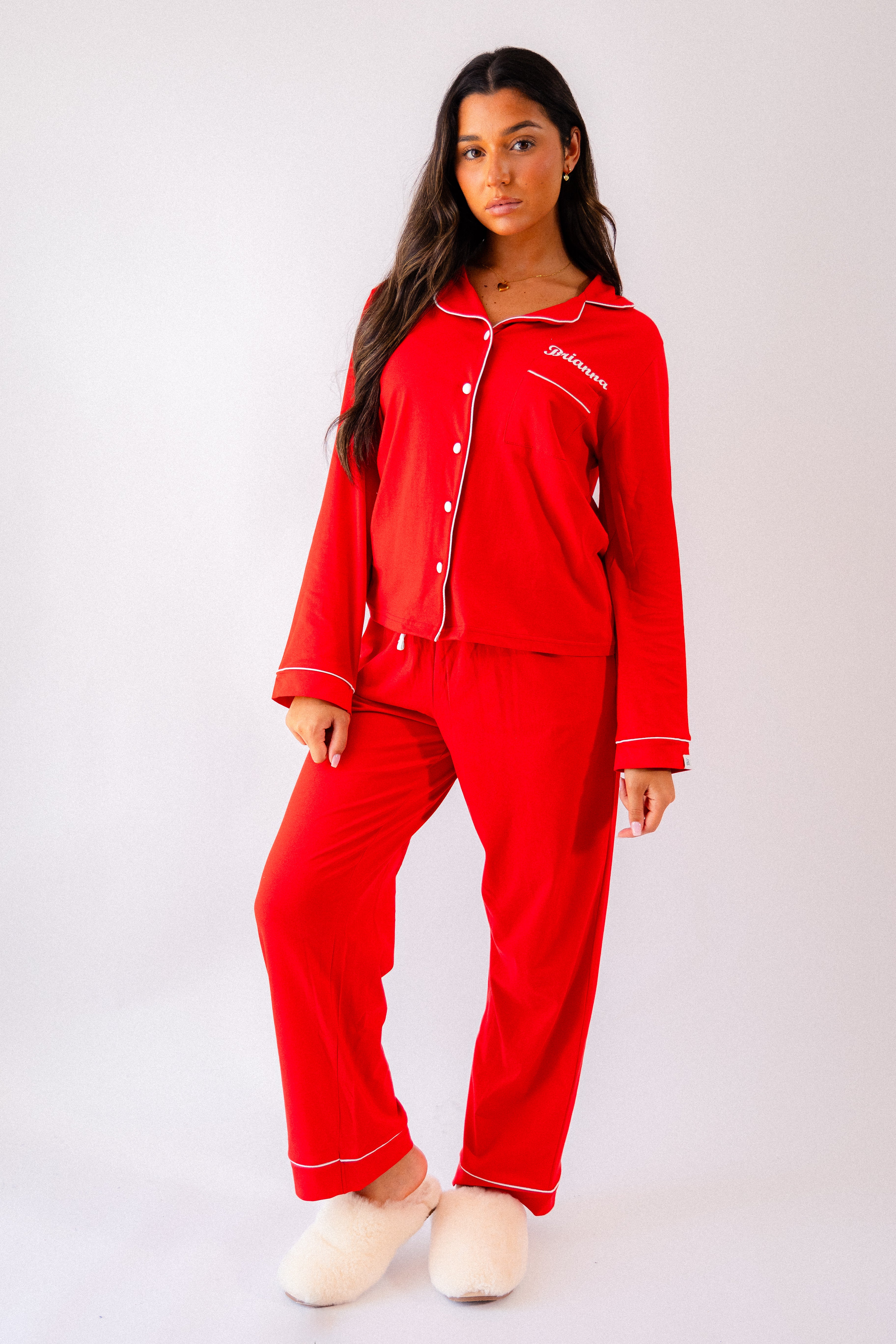 A beautiful set of ladies personalised red jersey pyjamas. Soft and comfortable personalisation above the front pocket on the left chest . White contrasting trim around the collar alongside the buttons down the front, also around the ankles and wrist A nice classy design with your comfort in mind. 