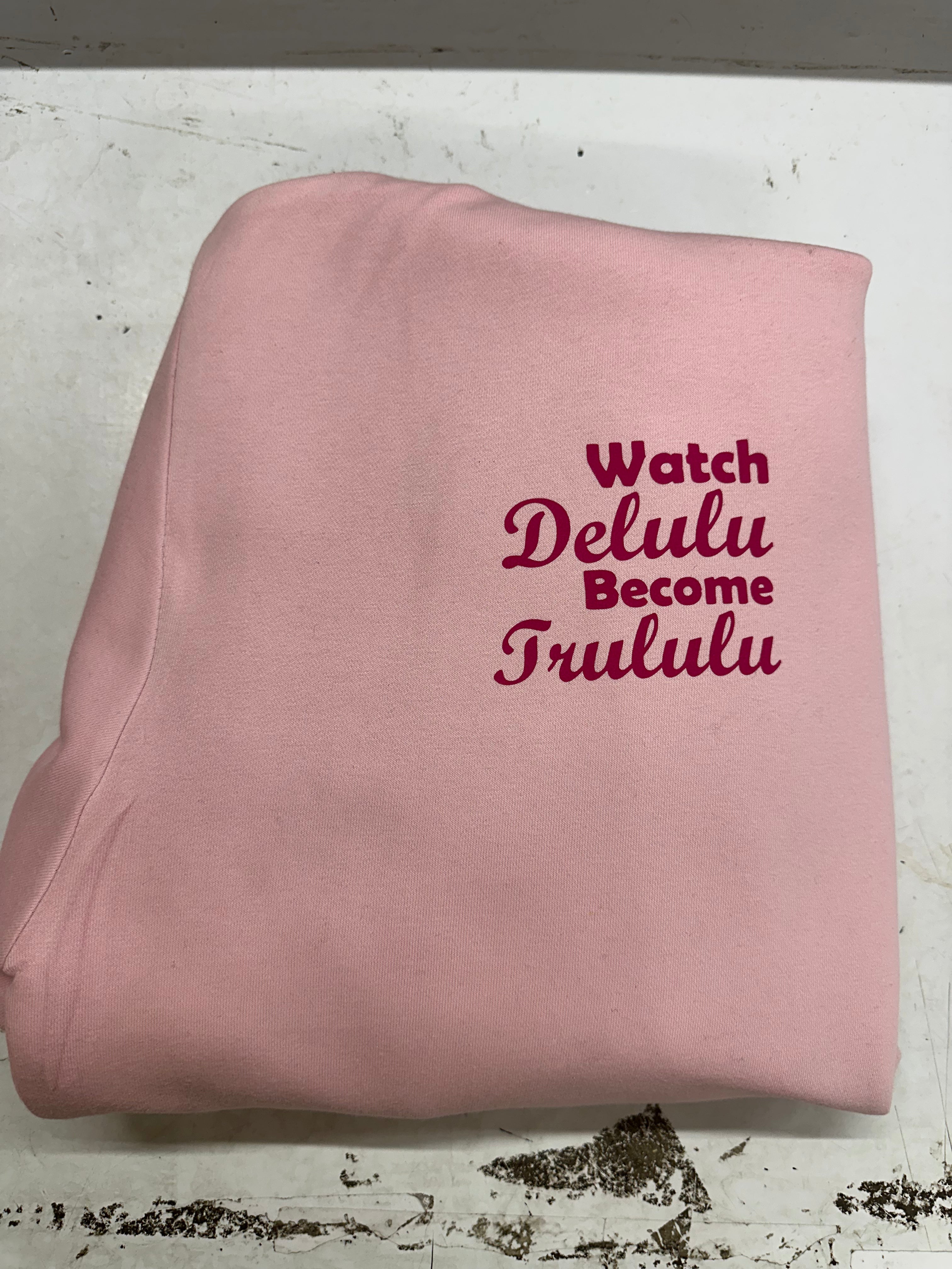  Comfortable ladies light pink cotton sweat pants with a printed design in a curvy printed hot pinkfont ... Watch Delulu become Trululu... A catchy design sure to catch peoples eye ! 