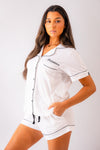 Ladies short jersey pyjamas in White with a Black contrast satin piping and buttons. Short sleeve button shirt with a pocket to the right of the chest and your personalised name above. Shorts with both pockets and an adjustable tie around the waist. 