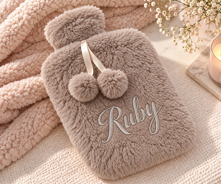 Personalised hot water bottle in a Mink colour. Created from a premium borg fabric with a name embroidered on the front cover of the hot water botttle and a rubber insert of 2L inside. 